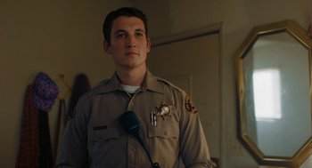 Movie still from “Too Old to Die Young” (2019), directed by Nicolas Winding Refn – A man in a police uniform is holding a microphone; Medium shot, Low angle