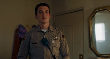 Movie still from “Too Old to Die Young” (2019), directed by Nicolas Winding Refn – A man in a police uniform with a microphone in his hand; Medium shot, Low angle