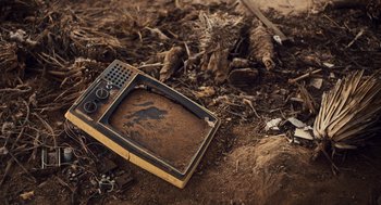 Movie still from “Too Old to Die Young” (2019), directed by Nicolas Winding Refn – An old tv sitting on top of a pile of dirt; Close Up shot, High angle