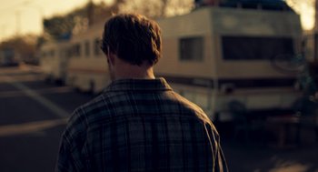 Movie still from “Too Old to Die Young” (2019), directed by Nicolas Winding Refn – A man in a plaid shirt is standing in front of an rv; Close Up shot, Over the shoulder angle