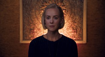 Movie still from “Too Old to Die Young” (2019), directed by Nicolas Winding Refn – A woman with short blonde hair wearing a black sweater; Close Up shot, Low angle