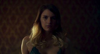 Movie still from “Too Old to Die Young” (2019), directed by Nicolas Winding Refn – A woman with long blonde hair is posing for the camera; Close Up shot, Low angle