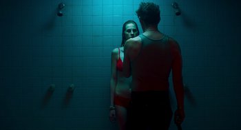 Movie still from “Too Old to Die Young” (2019), directed by Nicolas Winding Refn – A man and a woman standing in a bathroom; Medium shot, Low angle