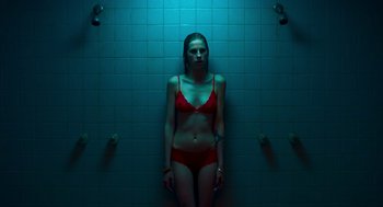 Movie still from “Too Old to Die Young” (2019), directed by Nicolas Winding Refn – A woman in a red bikini standing in a shower; Medium shot, Overhead angle