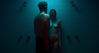 Movie still from “Too Old to Die Young” (2019), directed by Nicolas Winding Refn – A man and a woman standing next to each other in a bathroom; Medium shot, Low angle