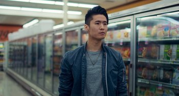 Movie still from “Too Old to Die Young” (2019), directed by Nicolas Winding Refn – A man standing next to a refrigerator in a store; Close Up shot, Low angle