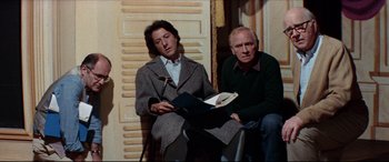 Movie still from “Tootsie” (1982), directed by Sydney Pollack – A man and a woman sitting next to each other holding papers; Medium shot, Low angle