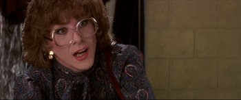 Movie still from “Tootsie” (1982), directed by Sydney Pollack – An older woman wearing glasses and a blue and red dress; Close Up shot, Over the shoulder angle