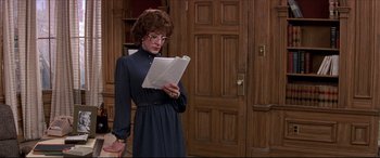Movie still from “Tootsie” (1982), directed by Sydney Pollack – A woman in a blue dress holding a piece of paper; Medium shot, Over the shoulder angle