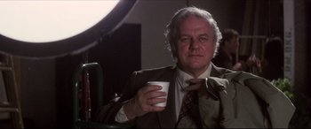 Movie still from “Tootsie” (1982), directed by Sydney Pollack – An older man in a suit holding a coffee cup; Medium shot, Low angle
