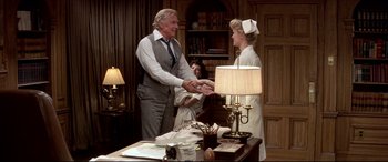 Movie still from “Tootsie” (1982), directed by Sydney Pollack – A man and a woman shake hands in front of a lamp; Medium shot, Over the shoulder angle