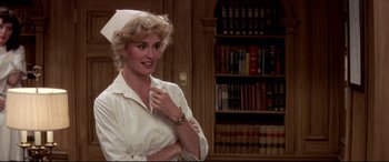 Movie still from “Tootsie” (1982), directed by Sydney Pollack – A woman in a nurse's uniform standing in front of a bookshelf; Medium shot, Over the shoulder angle