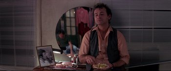 Movie still from “Tootsie” (1982), directed by Sydney Pollack – A man sitting in front of a mirror eating food; Medium shot, Over the shoulder angle