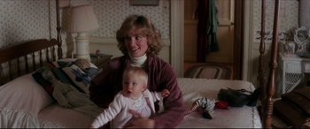 Movie still from “Tootsie” (1982), directed by Sydney Pollack – A woman and a baby sitting on a bed; Medium shot, High angle