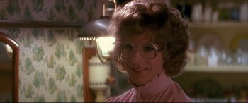 Movie still from “Tootsie” (1982), directed by Sydney Pollack – A person wearing glasses and smiling; Close Up shot, Over the shoulder angle