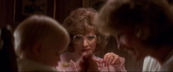 Movie still from “Tootsie” (1982), directed by Sydney Pollack – A woman with glasses looking at her reflection in a mirror; Close Up shot, Over the shoulder angle