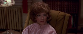 Movie still from “Tootsie” (1982), directed by Sydney Pollack – A woman sitting in a chair wearing a pink shirt; Close Up shot, Over the shoulder angle