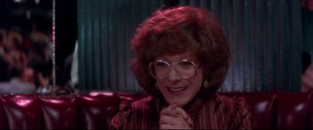 Movie still from “Tootsie” (1982), directed by Sydney Pollack – A woman with glasses sitting on a couch; Close Up shot, Over the shoulder angle