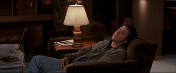 Movie still from “Tootsie” (1982), directed by Sydney Pollack – A man sitting in a chair next to a lamp; Medium shot, High angle