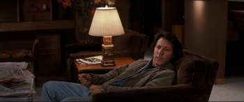 Movie still from “Tootsie” (1982), directed by Sydney Pollack – A man sitting in a chair in front of a lamp; Medium shot, Over the shoulder angle