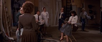 Movie still from “Tootsie” (1982), directed by Sydney Pollack – A group of people standing around in a room; Wide shot, Over the shoulder angle