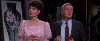 Movie still from “Tootsie” (1982), directed by Sydney Pollack – A man and a woman standing next to each other holding wine glasses; Medium shot, Over the shoulder angle