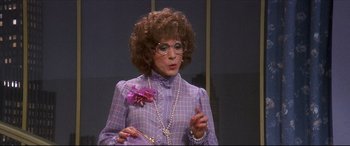 Movie still from “Tootsie” (1982), directed by Sydney Pollack – A woman in a purple dress holding a pink flower; Close Up shot, Over the shoulder angle