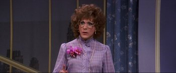 Movie still from “Tootsie” (1982), directed by Sydney Pollack – A woman in a purple dress with a purple flower in her hand; Close Up shot, Over the shoulder angle