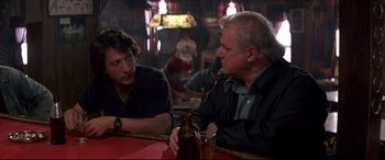 Movie still from “Tootsie” (1982), directed by Sydney Pollack – Two men are sitting at a table with a beer; Medium shot, Over the shoulder angle