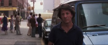 Movie still from “Tootsie” (1982), directed by Sydney Pollack – A man standing on the side of the road near cars; Close Up shot, Over the shoulder angle