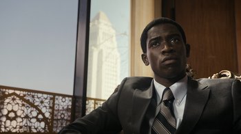 Movie still from “Snowfall” (2017), directed by Hiro Murai – A man in a suit and tie looking out a window; Close Up shot, Low angle