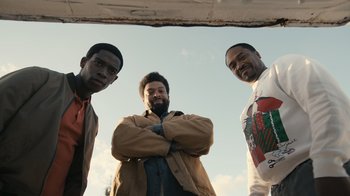 Movie still from “Snowfall” (2017), directed by Hiro Murai – A group of men standing next to each other; Medium shot, Low angle