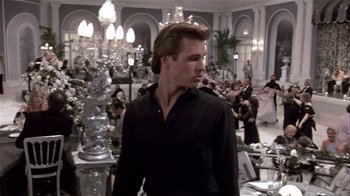 Movie still from “Top Secret!” (1984), directed by Jim Abrahams – A man standing in a room filled with crystal chandeliers; Medium shot, Over the shoulder angle