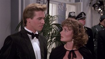 Movie still from “Top Secret!” (1984), directed by Jim Abrahams – A man and a woman in formal wear standing next to each other; Close Up shot, Over the shoulder angle
