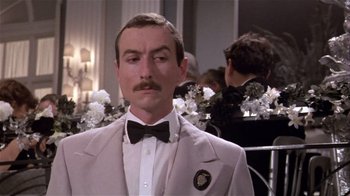 Movie still from “Top Secret!” (1984), directed by Jim Abrahams – A person wearing a suit and a bow tie; Close Up shot, Low angle