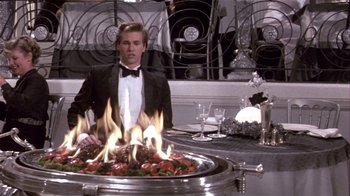 Movie still from “Top Secret!” (1984), directed by Jim Abrahams – A man standing in front of a fire pit; Medium shot, High angle