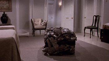 Movie still from “Top Secret!” (1984), directed by Jim Abrahams – A room filled with lots of clothes and a chair; Wide shot, High angle