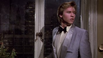 Movie still from “Top Secret!” (1984), directed by Jim Abrahams – A man in a suit and bow tie standing in front of a door; Medium shot, Low angle