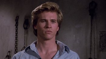 Movie still from “Top Secret!” (1984), directed by Jim Abrahams – A man with blonde hair is looking at the camera; Close Up shot, Low angle