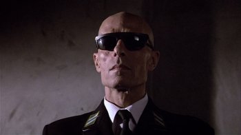 Movie still from “Top Secret!” (1984), directed by Jim Abrahams – A man wearing sunglasses and a uniform; Close Up shot, Low angle