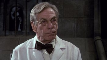 Movie still from “Top Secret!” (1984), directed by Jim Abrahams – An older man wearing a white lab coat and bow tie; Close Up shot, Low angle