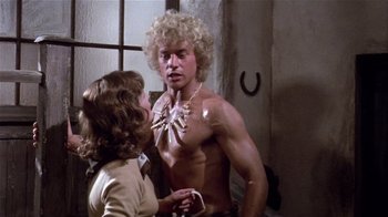 Movie still from “Top Secret!” (1984), directed by Jim Abrahams – A woman is talking to a shirtless man; Medium shot, Over the shoulder angle