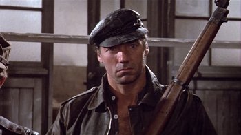 Movie still from “Top Secret!” (1984), directed by Jim Abrahams – A person holding a gun; Close Up shot, Low angle