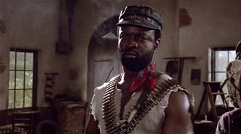 Movie still from “Top Secret!” (1984), directed by Jim Abrahams – A man with a beard and a hat is wearing a vest; Close Up shot, Low angle