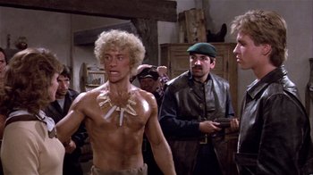 Movie still from “Top Secret!” (1984), directed by Jim Abrahams – A group of men standing next to each other in a room; Medium shot, Over the shoulder angle