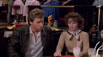 A man and a woman sitting at a table in front of drinks
