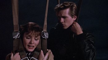 Movie still from “Top Secret!” (1984), directed by Jim Abrahams – A man and a woman are hanging from a swing; Medium shot, Over the shoulder angle
