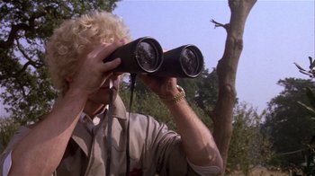 Movie still from “Top Secret!” (1984), directed by Jim Abrahams – A man looking through a pair of binoculars; Close Up shot, Low angle