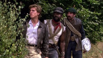 Movie still from “Top Secret!” (1984), directed by Jim Abrahams – A group of men standing next to each other in a forest; Medium shot, Low angle