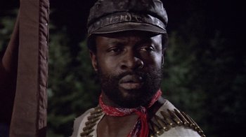 Movie still from “Top Secret!” (1984), directed by Jim Abrahams – A man with a beard and a hat on; Close Up shot, Low angle
